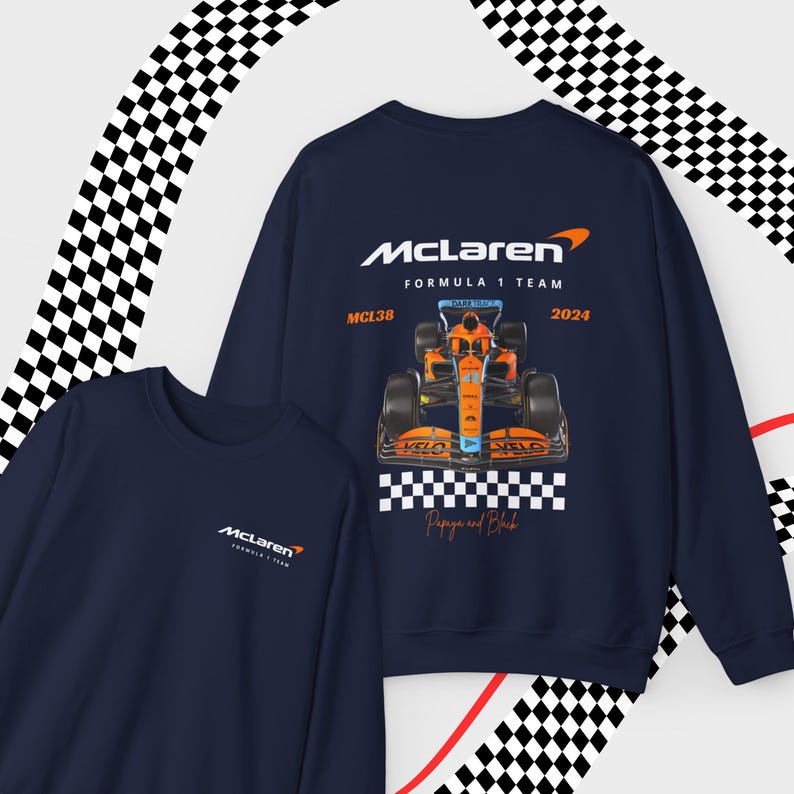 Puede incluir: Una sudadera azul marino con un logotipo de McLaren Formula 1 Team y un gr&aacute;fico de un coche de carreras. El coche es naranja y azul con el texto "MCL38" y "2024" en &eacute;l. El texto "Papaya and Black" est&aacute; debajo del coche.