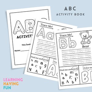 May include: A stack of white ABC activity books with black outlines. The cover reads "ABC ACTIVITY BOOK". Inside pages feature tracing exercises for letters A and B, with a teddy bear illustration. The phrase "LEARNING HAVING FUN" is at the bottom.