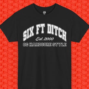 Pode incluir: Uma t-shirt preta de manga curta com texto branco estampado no peito. O texto diz SIX FT DITCH numa fonte universitária, seguido de Est. 2000 e OG HARDCORE STYLE numa fonte mais pequena. A t-shirt tem um decote redondo.