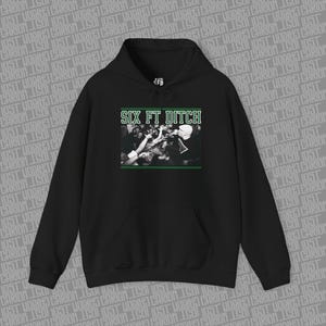Puede incluir: Sudadera con capucha negra con bolsillo delantero y capucha. La parte delantera presenta el texto "SIX FT DITCH" en verde, sobre una imagen en blanco y negro de una multitud. La sudadera está hecha de un material suave.