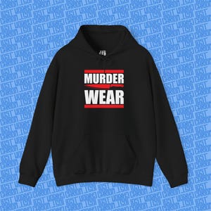 Puede incluir: Sudadera con capucha negra con el texto "MURDER WEAR" en letras blancas, un gráfico de cuchillo rojo y líneas horizontales rojas. La sudadera tiene un bolsillo delantero y una capucha con cordón. El fondo tiene un patrón de texto repetido.