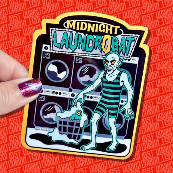 Nosferatu rising from a laundromat basket is the specific, nerdy pun energy that makes a sticker actually worth sticking — 'Laundrobat' is a genuinely clever wordplay execution.