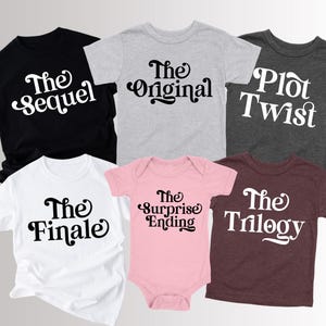 May include: A collection of children's t-shirts and a onesie in various colors, each printed with a different phrase in a retro font. The phrases include "The Sequel," "The Original," "Plot Twist," "The Finale," "The Surprise Ending," and "The Trilogy."