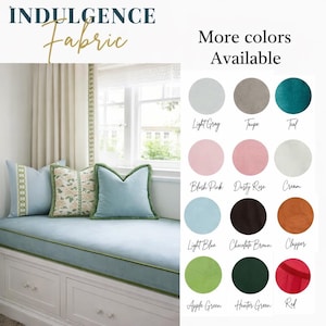 May include: A window seat with light blue cushions and pillows, trimmed with green piping and fringe. The image includes a color palette with options like light gray, teal, and dusty rose. The text reads "Indulgence Fabric" and "More colors Available."