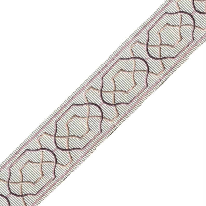 May include: Decorative ribbon with a repeating geometric pattern. The ribbon features a light gray background with thin diagonal lines. The pattern consists of interlocking shapes in shades of brown and dark purple, outlined with a thin pink border.