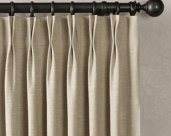 May include: Beige linen curtains with pleats hanging from a black metal curtain rod with a finial.