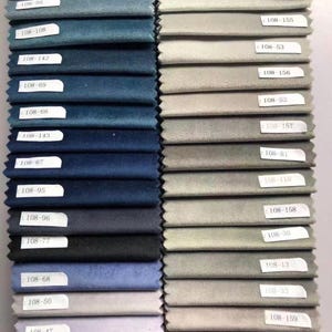 May include: A collection of fabric swatches in various colors, including shades of blue, gray, and pink. Each swatch has a label with a number. The swatches are arranged in vertical rows, showcasing a range of textures and hues.