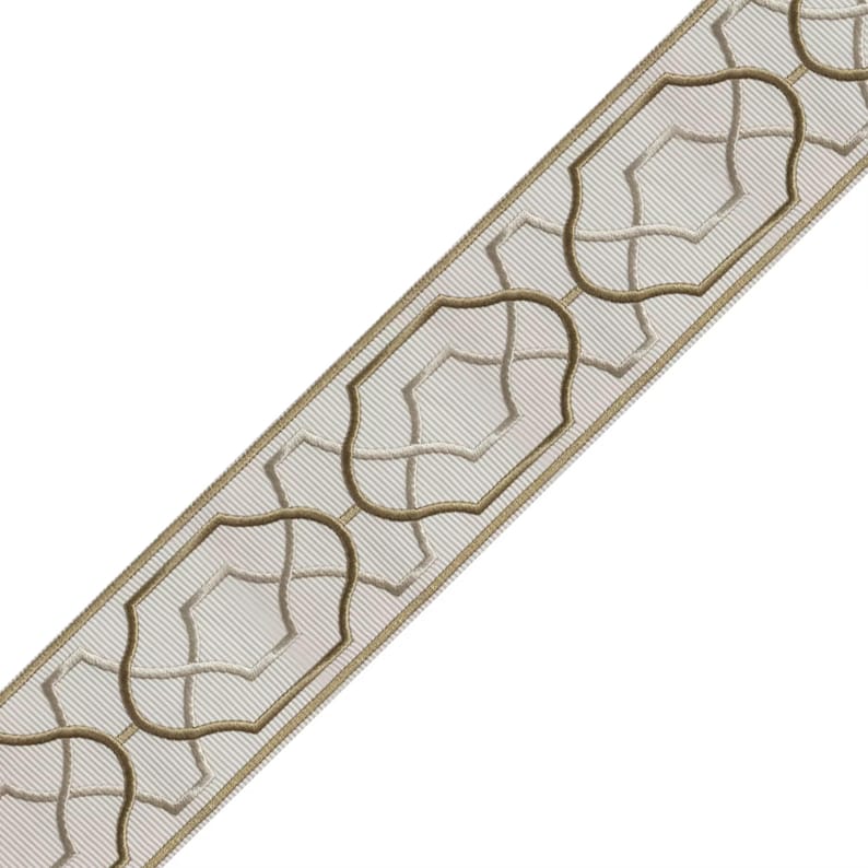 May include: Decorative ribbon featuring a repeating pattern of stylized, light brown geometric shapes outlined in a darker brown. The ribbon has a light beige background with subtle diagonal lines, creating a textured appearance. Ideal for crafts and home decor projects.
