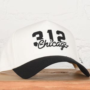 May include: A handmade, wooden cutting board with a natural finish. The board features a live edge on one side and a smooth, rectangular shape. It is approximately 18 inches long and 12 inches wide.