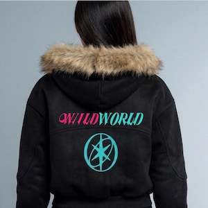 May include: A black hooded jacket featuring a faux fur trim on the hood. The back displays the text WILDWORLD in pink and teal lettering, positioned above a teal circular graphic containing a star-like symbol with intersecting curved lines.