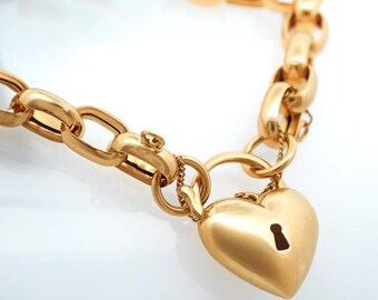 May include: Gold-toned chain bracelet featuring a heart-shaped padlock pendant. The bracelet has a series of oval links and a secure clasp. The heart-shaped pendant has a keyhole detail, adding a romantic touch to the jewelry.