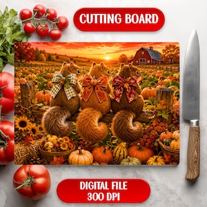 May include: A rectangular cutting board featuring a printed scene of three squirrels with bows sitting on a fence in a pumpkin patch at sunset, with a red barn in the background. The board is displayed with a kitchen knife and fresh tomatoes.