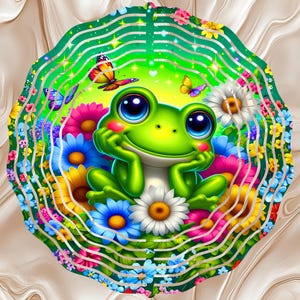 May include: A whimsical illustration of a smiling green frog with large blue eyes, resting its chin on its hands. The frog is surrounded by colorful flowers and butterflies, set against a green and white background.