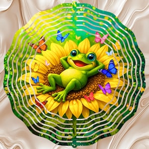 May include: A whimsical garden spinner featuring a cartoon frog relaxing on a sunflower. The frog is green with blue eyes and a red mouth. Colorful butterflies in shades of orange, blue, pink, and purple surround the flower. The background has a wavy, layered design.