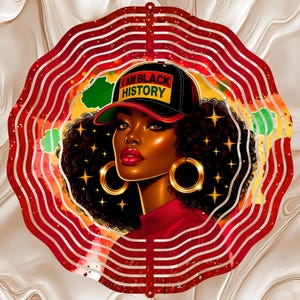 May include: A decorative image featuring a woman with dark skin, wearing a black cap with "I AM BLACK HISTORY" text. She has large gold hoop earrings and red lipstick. The image is set within a red and white striped circular frame, with a swirling background.