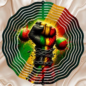 May include: A circular metal wind spinner featuring a central graphic of a raised fist wrapped in broken chains. The design incorporates vibrant red, yellow, and green colors with a cracked texture effect, surrounded by concentric wavy cutouts.