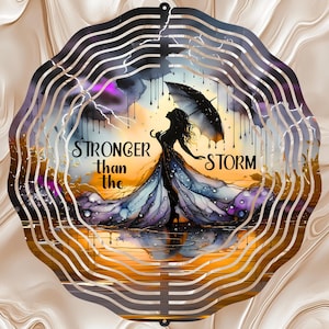 Könnte beinhalten: Ein dekorativer Metall-Windspinner mit einer Frau mit einem Regenschirm in einem Sturm. Das Kunstwerk enthält den Text "STRONGER than the STORM" mit einem Aquarelleffekt, vor dem Hintergrund von Regen, Blitzen und einem orange-violetten Himmel.
