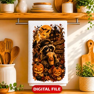 May include: A white waffle-weave kitchen towel featuring a graphic of a raccoon wearing a baseball cap and heart-shaped sunglasses while holding a pumpkin-themed drink. The scene includes pumpkins, a ghost, a haunted house, and signs reading PUMPKIN PATCH, HAY RIDES, and CORN MAZE.