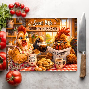 Peut inclure: Une planche &agrave; d&eacute;couper rectangulaire illustr&eacute;e de deux poulets dans une cuisine. L'un verse du caf&eacute; dans une tasse marqu&eacute;e Sweet Chick, l'autre lit un journal intitul&eacute; Mr. Grumpy. Le texte indique Sweet Wife GRUMPY HUSBAND.