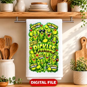 May include: A white waffle-textured kitchen towel featuring a colorful graphic of cartoon pickles with various expressions and accessories. The text includes phrases like You're a big dill to me, Talk pickle to me, I'm kind of a big dill, Just dill with it, In a pickle again, and In a pickle mood.