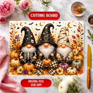 May include: A rectangular cutting board featuring three gnomes in Halloween attire, including skeleton and mummy themes, surrounded by autumn leaves, pumpkins, and stars. The design includes bats and crescent moons on a cream background.
