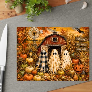 K&ouml;nnte beinhalten: Ein rechteckiges Glasschneidebrett mit einer herbstlichen Bauernhofszene und drei Geistern vor einer roten Scheune. Das Motiv zeigt K&uuml;rbisse, eine Windm&uuml;hle und ein Schild mit der Aufschrift PUMPKINS, HAY RIDES und CORN MAZE in Oranget&ouml;nen.