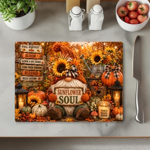 May include: A rectangular glass cutting board featuring a gnome wearing a sunflower-adorned hat, holding a sign that reads Sunflower Soul. The scene includes pumpkins, lanterns, a watering can, and a wooden signpost with autumn-themed text.
