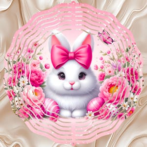 May include: A cute white bunny with a pink bow and pink-painted Easter eggs is surrounded by pink flowers. The bunny is inside a pink, wavy-edged frame with a butterfly. The background has a marble-like pattern.