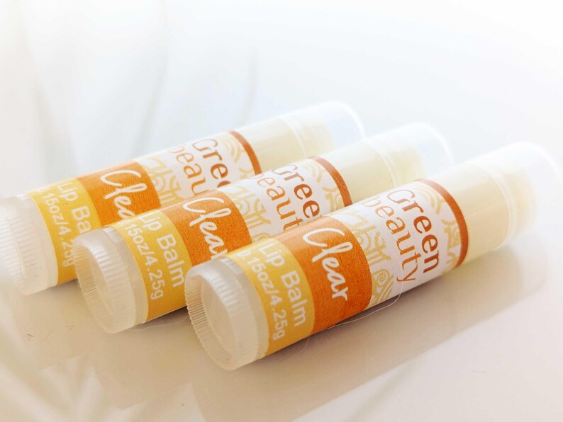 May include: Three clear lip balm tubes with yellow and white labels that read "Green Beauty Clear Lip Balm 1.5 oz/4.25g".