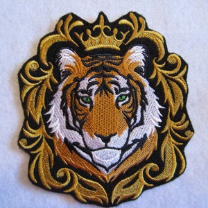 May include: Embroidered iron-on patch featuring a tiger's face with green eyes, surrounded by a gold ornate frame. The tiger is wearing a gold crown.