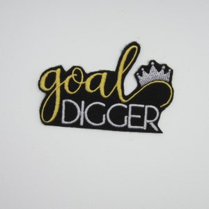 May include: Black embroidered iron-on patch with gold lettering that says "goal digger" and a silver crown.