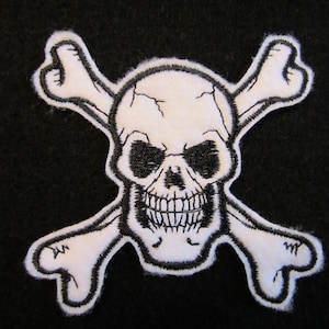 May include: White skull and crossbones patch with black stitching. The skull has a menacing expression with black eyes and a toothy grin.