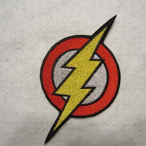 May include: Red and yellow embroidered patch with a lightning bolt inside a circle. The lightning bolt is yellow and the circle is red with a white outline.