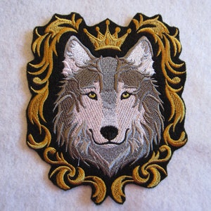May include: Embroidered iron-on patch featuring a gray wolf's head with a gold crown above it. The wolf is surrounded by a gold ornate frame.