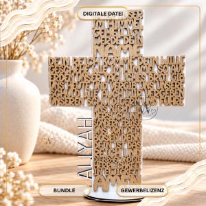 May include: A cross-shaped wooden wall decor piece featuring the Lord's Prayer in German text cutouts. The light brown wooden letters are mounted on a white background. The name Aliyah is vertically displayed on the left side of the cross.