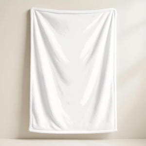 Back view product mockup displaying the plain solid white fleece backing of a custom plush throw blanket for the Elliot design from the Roblox game Forsaken by KraftilyEm. Shows the soft, fluffy textured white lining with finished hemmed edges hanging against a neutral beige wall. Highlights the high-quality cozy material and construction of the gamer throw. An essential detail shot for buyers evaluating custom Roblox fan art merchandise and cozy bedroom decor accessories.
