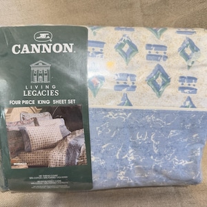 May include: A Cannon Living Legacies four-piece king sheet set. The sheets have a blue and white geometric pattern. The packaging shows a picture of the sheets on a bed. The set includes a 180 thread count and is made of 50% cotton and 50% polyester.