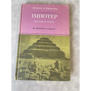 May include: A vintage book titled "Imhotep Builder in Stone" by Maribelle Cormack. The cover features a pink header with the title and a green and yellow image of an ancient stepped pyramid. The book is part of the "Immortals of Engineering" series.
