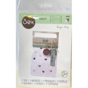 Peut inclure: Un ensemble de matrices de découpe Sizzix Thinlits pour le bricolage. L'emballage présente un motif de sac en papier avec des cœurs, une étiquette avec l'inscription "with love" et une étiquette ronde marron. Le texte "11 DIES | 11 MATRICES | 11 TROQUELES | 11 FUSTELLE | 11 ВЫРУБКИ | 11 STANZEN | 11 CORTANTES" est également inclus.