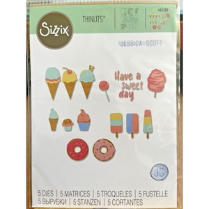 以下が含まれることがあります： Sizzix Thinlitsダイセット。アイスクリームコーン、カップケーキ、アイスキャンディー、ドーナツ、綿菓子のデザイン。 「Have a sweet day」のテキストが含まれており、Jessica Scottによって設計されています。
