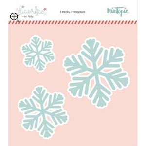 May include: Three snowflake die-cuts in varying sizes, in a light blue color with white outlines, are displayed on a pink background. The words "diciembre" and "3 PIEZAS / TROQUELES" are visible at the top. The brand name "Mintopic" is also visible.