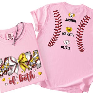 Pu&ograve; includere: Due magliette rosa chiaro con grafiche a tema softball. Una mostra la scritta "MOM of both" con un fiocco giallo e bianco. L'altra presenta cuciture rosse da softball, tre palline a forma di cuore e i nomi "JASMIN", "MARKUS" e "OLIVIA".
