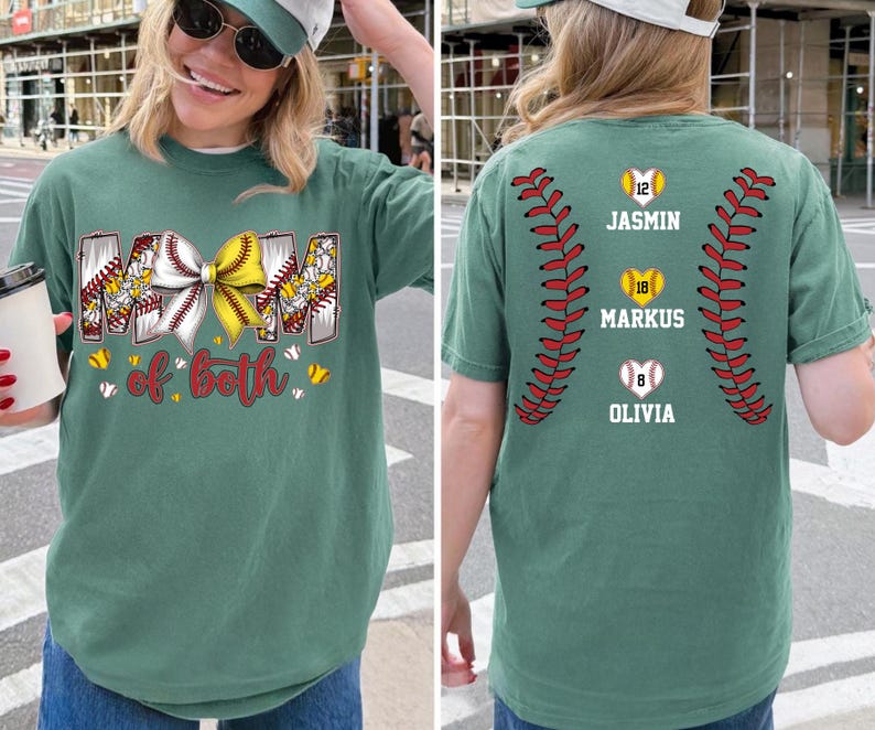 Pu&ograve; includere: Una t-shirt verde salvia con una grafica frontale che riporta il testo MOM of both e un fiocco giallo e bianco su un motivo da baseball. Il retro mostra due motivi di cuciture da baseball rosse, tre palline a forma di cuore con i numeri 12, 18, 8 e nomi.