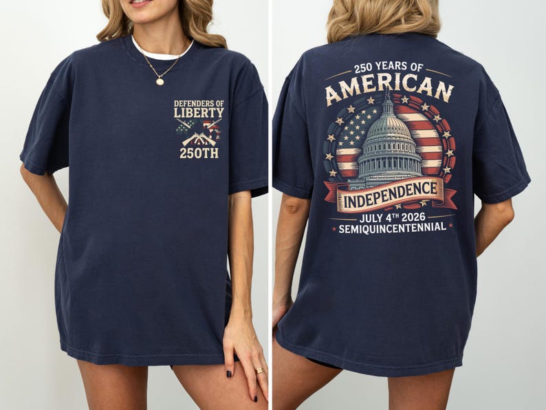 May include: Navy blue t-shirt with "Defenders of Liberty" and "250th" on the front. The back features a design commemorating 250 years of American Independence, including the Capitol building, the American flag, and the date July 4th, 2026.