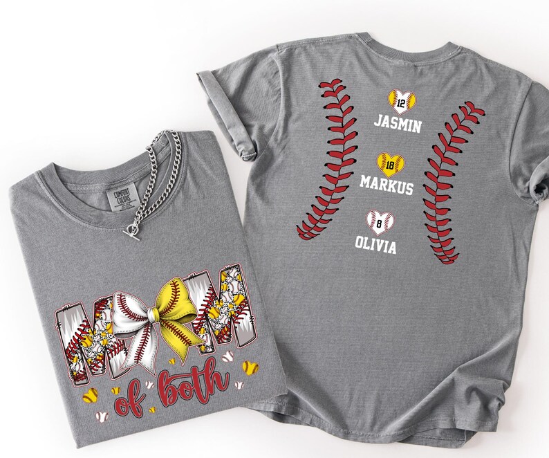 Pu&ograve; includere: Una t-shirt grigia con una grafica che riporta il testo MOM of both e un fiocco a tema baseball giallo e bianco. Il retro della maglia mostra due motivi di cuciture da baseball rosse, tre palline a forma di cuore e i nomi JASMIN, MARKUS, OLIVIA.