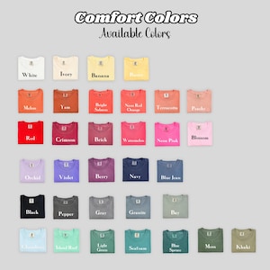 May include: A selection of Comfort Colors t-shirts in a range of colours, such as white, black, red, and blue. The text "Comfort Colors Available Colors" is at the top. Each shirt is folded, displaying the available shades.