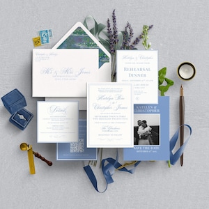 May include: Wedding stationery set featuring invitation cards, save-the-date cards, and an envelope with elegant calligraphy. A blue velvet ring box, a gold wax seal, and a pen with blue ribbon are also included. The theme is a wedding.
