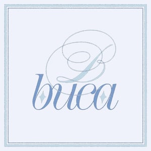 May include: A light blue square design with the word "buca" in a script font. The letter "B" is stylized with elegant swirls. The design is framed by a double light blue border, creating a clean and sophisticated look.