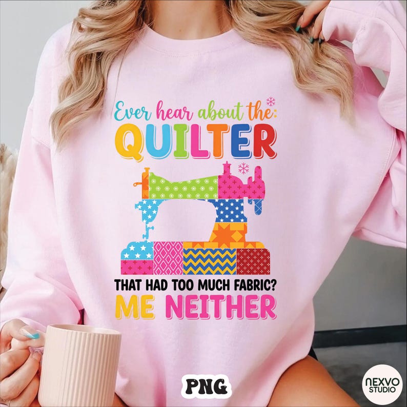 May include: A light pink sweatshirt with the text "Ever hear about the QUILTER that had too much fabric? ME NEITHER." A colorful sewing machine graphic is in the center. The sweatshirt is a crew neck style.
