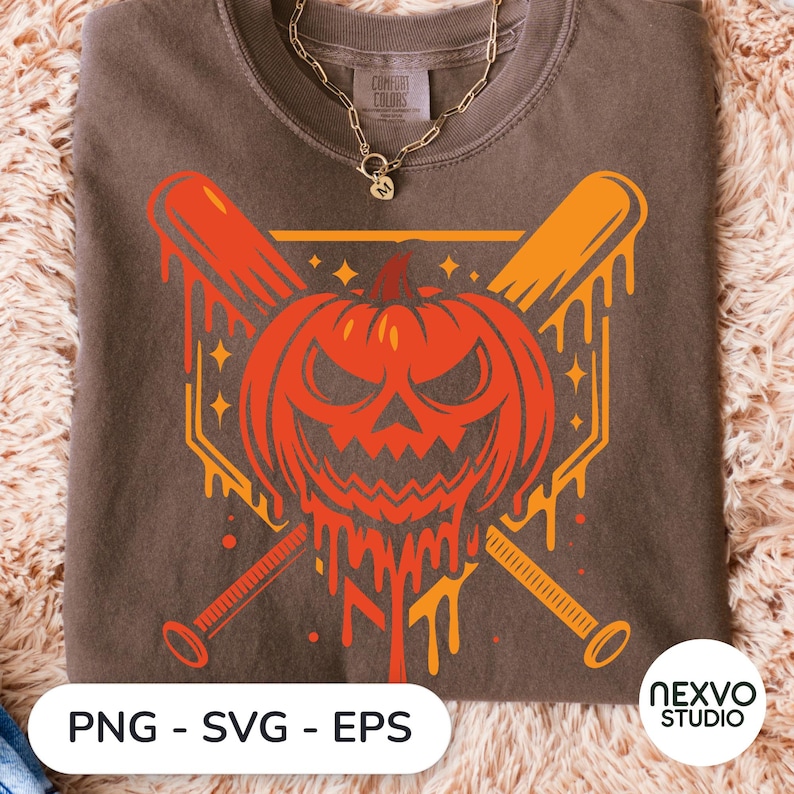 May include: A brown crewneck t-shirt featuring a graphic of a melting orange jack-o'-lantern centered over two crossed baseball bats. The design includes small star accents and a geometric border. The shirt has a Comfort Colors brand label at the neck.
